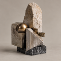 Full view of abstract geometric block sculpture with gold-toned orb and dark veined base, without text