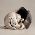 Full view of two nestled ivory and gold-toned figures within a dark cocoon, without text