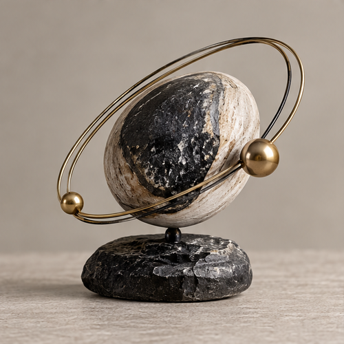 Full view of two-tone globe sculpture with twin orbital rings and two gold-toned spheres, without text